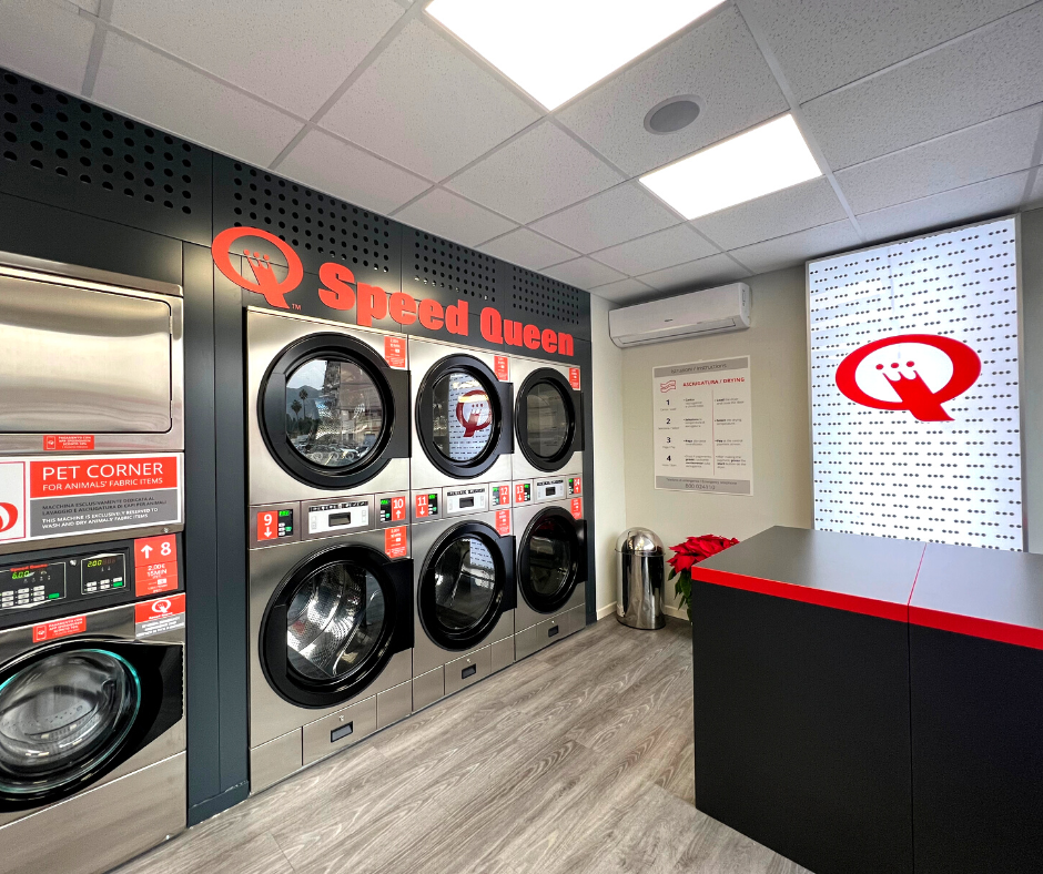 L’interno della lavanderia Speed Queen Palermo con asciugatrici professionali e area pet corner